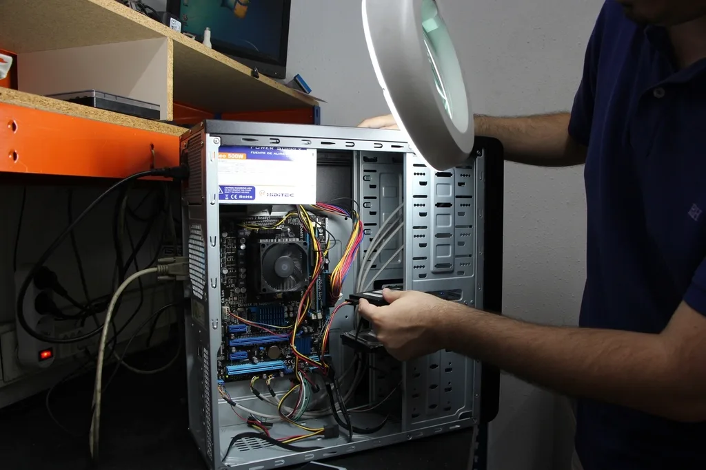 Técnico realizando manutenção interna em um computador.